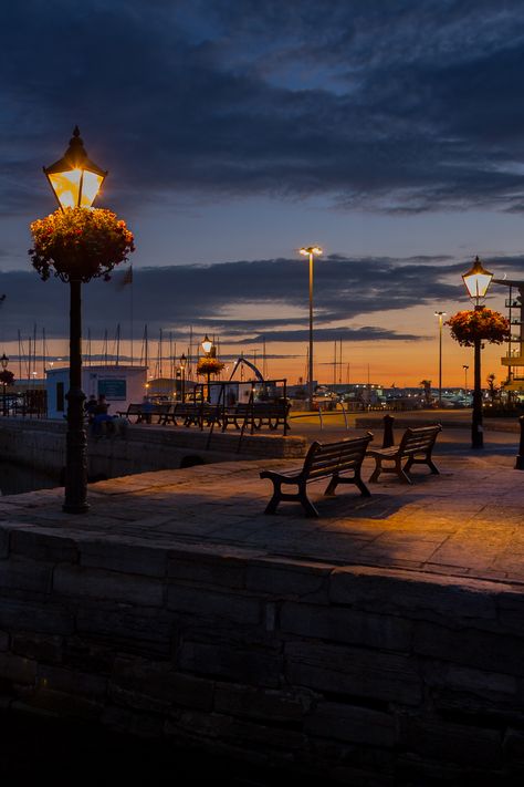 Poole Quay at dusk with orange and blue/black skies Poole Dorset, Cosy Season, Dorset England, Fall Getaways, The Sound Of Waves, Tourism Website, Evening Walk, Autumn Drives, Crashing Waves