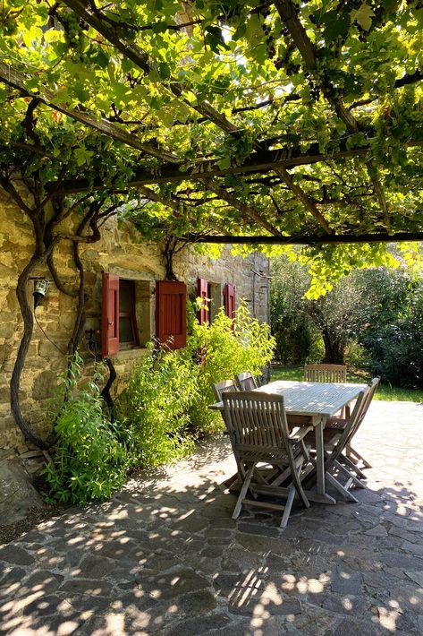 This gorgeous verdant pergola provides a wonderful shaded area for alfresco dining at this 3 bedroom country house, just 6km from the historic town of Cortona. Includes an annex to restore, 2 hectares of land with a pool and panoramic views. #tuscany #villa #farmhouse #rustic #house #tuscan #italian #forsale #property #realestate #dreamhome #inspo #cortona #arezzo #italy #alfresco #outdoorspaces #outdoordining #pergola #garden #dining #casatuscany #italy #toscana #italianvilla #tuscanvilla Italian Patios Tuscany Italy, Italian Villa Landscaping, Italian Countryside House Aesthetic, Italian Country Side House, Italian Patio Ideas Tuscany Italy, Italian Outdoor Dining, Italian Pergola, Italian Courtyard Garden, Tuscany Courtyard