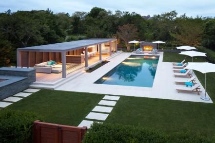 All the elements of an outdoor retreat, this poolside patio has a place for sun, shade, warmth on a cool night, and a spot to share meals with family and friends. Modern Pool Pergola, Pool Pergola, Modern Pool House, Moderne Pools, Pool House Designs, Modern Pool, Best Modern House Design, Modern Pergola, Pool Cabana