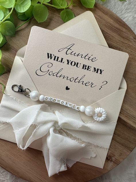 Make an unforgettable godmother proposal with this unique and practical card! Our elegant card is not only a touching way to ask someone special to be your child's godmother, but it also comes with an integrated keychain. Perfect for a daily keepsake that will make her smile every time! How To Ask Someone To Be A Godmother, Ideas For Godmother Proposal, Diy Godmother Proposal, Godmother And Godfather Proposal Ideas, Will You Be My Godmother Ideas, Cute Ways To Tell Your Best Friend You’re Pregnant, How To Ask To Be Godparents Good Ideas, How To Ask Someone To Be A Godparent, Will You Be My Godmother Proposal Ideas