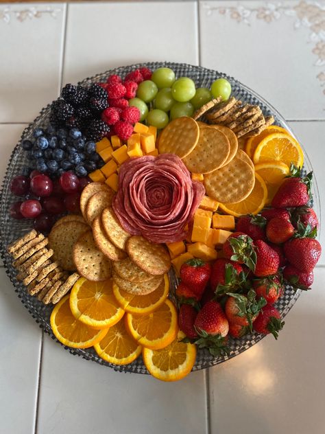 Charcuterie board surrounded with grapes, circular orange slices, blueberries, blackberries, strawberries, raspberries, mild cheddar cheese cubes, a different variety of crackers  and a salami rose. All on a circular platter. Cute Easy Charcuterie Board, Salami Cheese Fruit Platter, Fruit Cheese Cracker Platter, Fruit And Cracker Charcuterie Board, Cheese Board With Fruit, Cracker Cheese Board, Cheese Cracker Charcuterie Board, Cheese Salami Platter, Chacudory Board