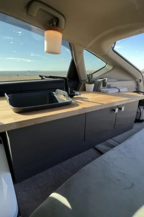 Camper van interior with a wooden countertop, sink, potted plant, and hanging light. Prius Camper, Prius Camping, Prius Car, Compact Camping, Essential Camping Gear, Convertible Bed, Multipurpose Furniture, Camper Living, New Possibilities