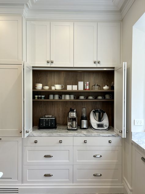 Custom designed polyurethane appliance cabinet, constructed in a timber grain Lamiwood with round LED lighting. Fitted with bi-fold opening doors and a 40mm natural stone benchtop. #kitchensbyemanuel #customjoinery #appliancecabinet #storagegoals #appliancecabinet Pantry Appliance Counter, Kitchen Appliance Station, Coffee Garage In Kitchen, Cabinets For Appliances, Kitchen With Appliance Garage, Cabinet With Appliance Garage, Kitchen Appliance Placement, Appliance Cupboard Kitchen, Appliance Cabinet Kitchen