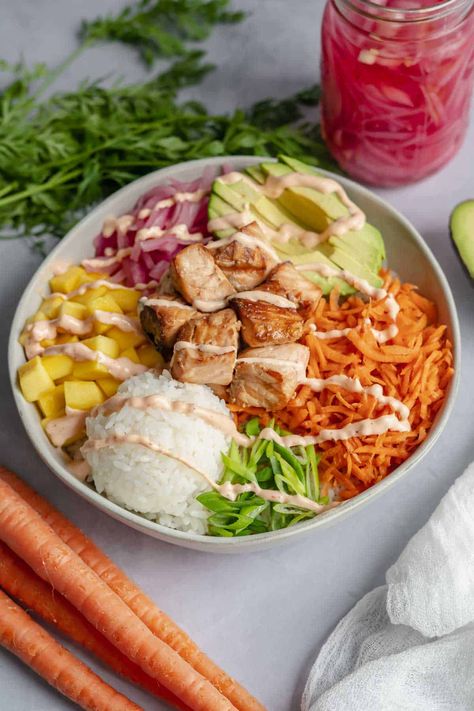 Looking for a healthy and delicious meal that's packed with protein and nutrients? Try this cooked salmon poke bowl recipe! The bowl features cooked salmon, rice, and a colorful array of fresh veggies like pickled onion, carrot, and avocado. The salmon is marinated in teriyaki sauce giving it a delicious Asian-inspired taste. This poke bowl is not only filling and nutritious, but it's also easy to make and customizable. Enjoy this tasty and wholesome meal for lunch or dinner! Healthy Lunch Ideas Fish, Powerbowl Lunch Recipes, Poke Bowl Lunch Prep, Sushi Salmon Bowl, Poke Bowl With Salmon, Salmon Poke Bowl Ideas, Salmon For Poke Bowl, Protein Bowls Lunch, Healthy Poke Bowl Recipe