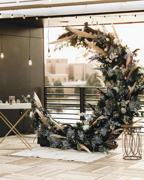 Half moon flower arch for outdoor wedding. Dusty Blue details with pampas grass #pampasgrass #weddingideas #fallweddingideas #fallweddingflowers #blueweddingideas #outdoorwedding #winterwedding #bellasposaevents #floridaweddingplanning Dark Wedding Arch Ideas, Wedding Arch Moon, Moon Altar Wedding, Wedding Moon Arch, Dark Wedding Arch, Halloween Wedding Arch, Moon Wedding Decor, Moon Arch Wedding, Crescent Moon Wedding