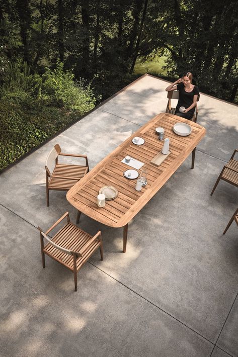 This Teak Outdoor Living Collection Pairs Sustainability and Scandinavian-Inspired Style - Photo 8 of 11 - Inspired by teak decking, and echoing the craftsmanship and design of the Tea Clippers that opened trade routes around the world, Pedersen clearly references his inspiration, using generous deck-like slats, ﬁnely tapered legs that hint at a ship’s mast—even giving the table a hull-like edge. The Clipper collection is simultaneously a nod to a nautical past, as well as a new take on al fresc Modern Outdoor Dining Sets, Modern Outdoor Dining Table, Outdoor Dining Table Setting, Modern Outdoor Dining, Teak Patio Furniture, Natural Teak Wood, Teak Outdoor Furniture, Mesa Exterior, Patio Dining Table