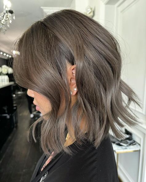 Elevate your fall look with a smoky gray wavy bob, a chic metallic style perfect for the season. This fall haircut offers a cool, contemporary vibe with soft waves and a unique color that stands out in autumn. Ideal for those who love experimenting with hair. Metallic Brown Hair, Ash Brown Hair Ideas, Natural Ash Brown Hair, Ashy Brown Hair Balayage, Silver Ash Hair, Medium Ash Brown Hair, Ashy Blonde Highlights, Brown Hair With Silver Highlights, Ashy Brown Hair