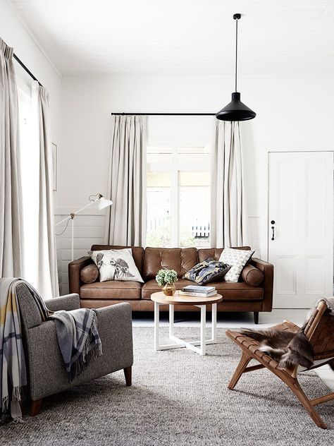 Masculine living space with black pendant chandelier, brown sofa, and small coffee table Sofa Kulit, Brown Living Room Decor, Brown Leather Couch, Furnitur Ruang Keluarga, Brown Couch, Brown Leather Sofa, Ideas Hogar, Trendy Living Rooms, Brown Living Room