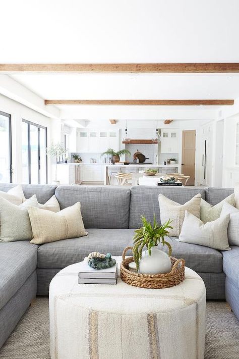 A round ivory ottoman coffee table sits on a gray rug in front of a blue-gray u-shaped sectional accented with ivory pillows. Ivory Ottoman, Ivory Pillows, Pure Salt Interiors, Pure Salt, Ottoman Decor, Apartment Decoration, Grey Sectional, Cottage Living Rooms, Ottoman Coffee