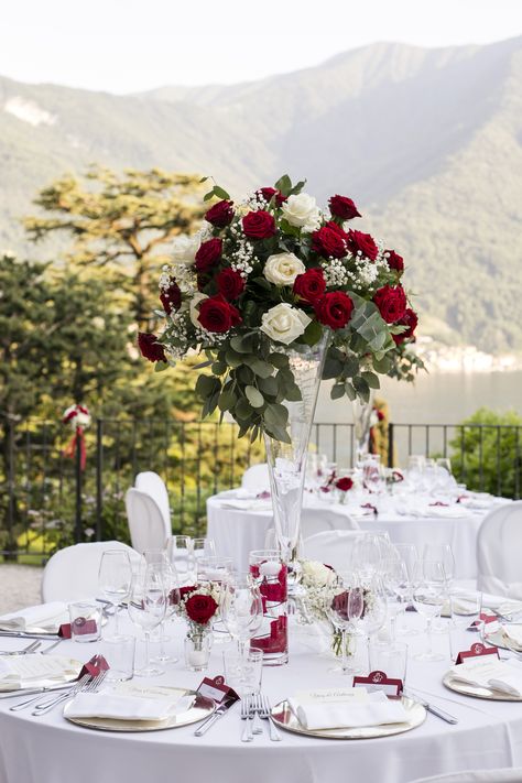 Tall Transparent vases topped with red and white roses, gypsophila and a touch of greenery Trumpet Centerpiece Wedding, Red White And Rose Gold Wedding, Wedding Decoration Red And White, Red Sage And White Wedding, Elegant Red Wedding Theme, White And Red Wedding Centerpieces, Red Rose Wedding Reception Decor, Red Roses And Greenery Centerpiece, Deep Red And White Wedding