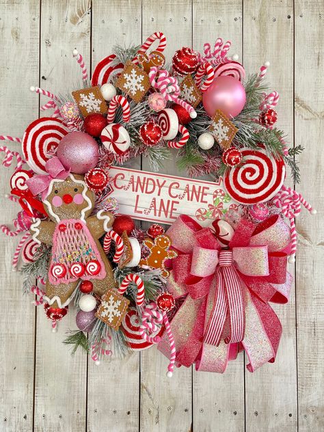 "28\" LARGE Christmas Winter Holiday Gingerbread  Candy Lane Red White and Pink wreath for your front door porch entrance entryway wall hanging home decor.    Completed wreath Measures approximately 28\"-30\"(W) x 8\"-10\"(D).  White glitter grapevine wreath frame, frosted pine greenery, Accented with Beautiful glittered multi ribbon bows red white & pink, CANDY CANE LANE MDF wood sign, Gingerbread attachment, peppermint & candy glitter sprays and ornaments, and various other Christmas candy accents.  **Indoor/Outdoor but for best longer lasting results display in a covered or protected area. Over time exposure to sun and weather may  cause some fading.... some materials more than others" Christmas Candy Front Porch, Pink Door Christmas Decor, Candy Cane Theme Wreath, Teal Red Pink Christmas, Candyland Christmas Front Porch, Pink Front Door Christmas Decor, Pink And White Christmas Wreath, Candy Canes Wreaths, Pink Red Christmas Wreath