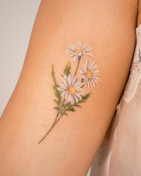 25 Delicate Daisy Tattoo Ideas To Save For Inspiration Black Daisy Tattoo, Delicate Daisy Tattoo, White Daisy Tattoo, Daisy Tattoo Ideas, Daisy Tattoo Meaning, Daisy Chain Tattoo, Daisy Tattoos, Resilience Tattoo, White Flower Tattoos