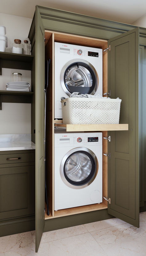 Compact laundry room upstairs with stacked washing machine and tumble dryer, green cabinetry, and pull-out shelf. Stackable Washer Dryer Laundry Room With Window, Hallway Washer And Dryer Closet, Lift Washer And Dryer, Laundry Room Remodel Stacked Washer Dryer, Bathroom Stackable Laundry Combo, Stacked Washer Dryer In Master Closet, Stackable Washer And Dryer Mudroom, Stacked Tumble Dryer And Washing Machine, Pull Out Table Laundry Room