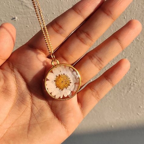 White Daisy Pendant with golden chain 🌸 Dm us to buy. Bezel : @resinsm_silicone_moulds White daisy. : @craft__supply #resinjewelry #resinartwork #resinearrings #jewellery #handmaderesinjewelry #smallbusiness #giftjewelry #preservationresin #dryflowerresinjewelry #resinhandmadejewellery #originalflowerjewellery #resininkjewellery #floralresinjewelry #resinearstuds#whitedaisyjewellery Flower Resin Jewelry, Daisy Pendant, Silicone Moulds, Golden Chain, Resin Artwork, White Daisy, Craft Supply, Flower Jewellery, Ear Studs