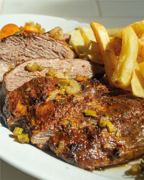 Disfrutá de esta riquísima TAPA DE NALGA CON PAPAS FRITAS, con la carne adobada con perejil, salsa inglesa y otros condimentos. PROCEDIMIENTO: Sellar la tapa por ambos lados en una plancha o chapa. Retirar y reservar. En un bowls mezclar todos los ingredientes del adobo y luego masajear la carne dejándola reposar al menos por media hora. En una asadera disponer los vegetales cortados a groso modo y cubrir la placa con agua hasta la mitad. Agregar la carne y l Carne Adobada, Adobo, Media