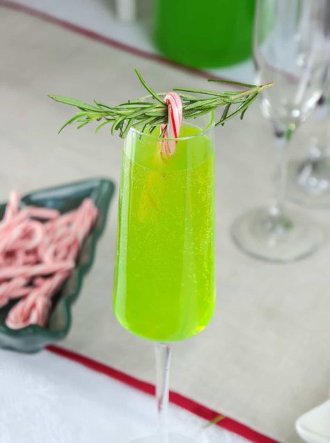 Channel your inner Grinch with our Grinch Mimosa – a mischievously delicious holiday concoction that combines the tartness of green apple and the sweetness of champagne, all wrapped up in a playful green hue. Perfect for those who love a little holiday fun in every sip! Green Holiday Drinks, Grinch Mimosa Recipe, Green Christmas Drinks For Adults, Green Christmas Cocktails, Grinch Champagne Drink, Scooby Snack Shot, Melon Liqueur, Christmas Breakfast Recipe, Christmas Recipes Easy