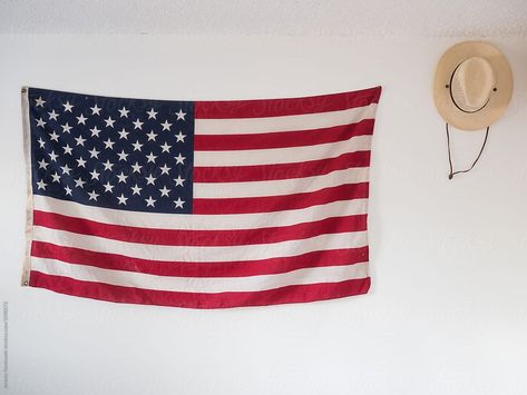 American Flag And Straw Hat Hanging On Wall Of Bedroom As Decoration | Stocksy United  Lifestyle and travel stock photos by canyoncreative.co  #america #americana #4thofjuly #freedom #americanflag #stockphoto American Flag Hanging On Wall, Hat Hanging On Wall, American Flag On Wall, American Flag Room, Anerican Flag, Flag On Wall, American Flag Banner, American Flag Wall, Flag Hanging