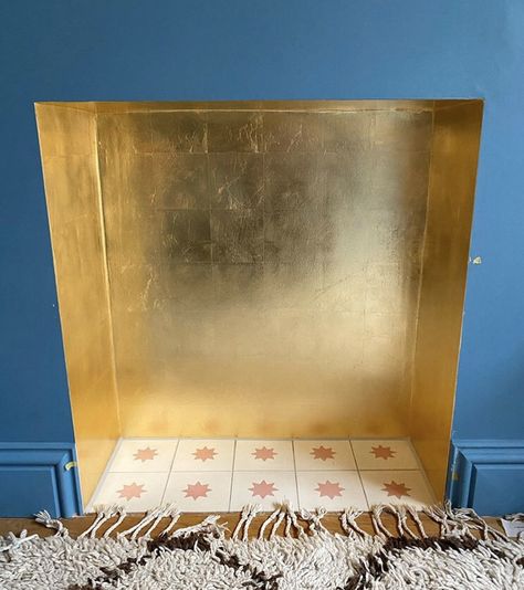 Gold leaf fireplace with starburst tiles and no surround Gold Tiles Fireplace, Gold Leaf Fireplace Surround, Gold Painted Fireplace, Gold Leaf Decor Interior Design, Gold Fireplace Mantle, Gold Leaf Interior, Gold Leaf Fireplace, Gold Fireplace Makeover, Wallpapered Fireplace