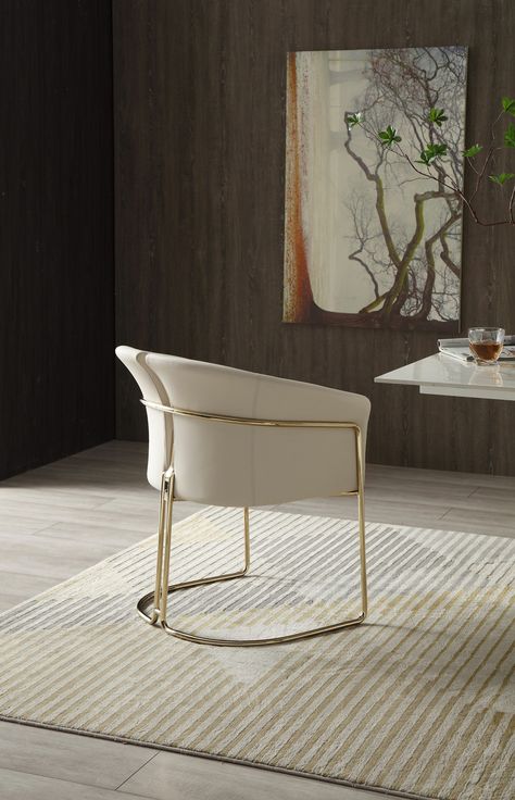 Enjoy the perfect blend of comfort and style with the Modrest Renfew Dining Chair. This chair is upholstered with modern beige Vegan leather, and its champagne gold stainless steel legs and frame combine to create a stunning addition to any dining space. It pairs wonderfully with a white marble or light wood dining table. It can hold up to 300 lbs., has plastic glides to protect floors, and requires no assembly. Single Seat Armchair Upholstered In Vegan Leather Upholstery Color: Beige Split Back Champagne Dining Chairs, Dining Chairs Gold, Ivory Leather Dining Chairs, Tan Leather Dining Chairs With Arms, Light Wood Dining Table, White Gold Modern Dining Chairs Faux Leather, Hollywood Glam Furniture, Gold Dining Chairs, Gold Dining