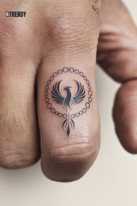 Small circular phoenix tattoo on the finger Behind The Ear Phoenix Tattoo, Phoenix Finger Tattoo, Phoinex Tattoos Women, Phoenix Tattoo Feminine Small For Women, Tiny Phoenix Tattoo, Phoenix Tattoo Design Feminine, Minimalist Phoenix Tattoo, Phoenix Feather Tattoos, Phoenix Tattoo Ideas