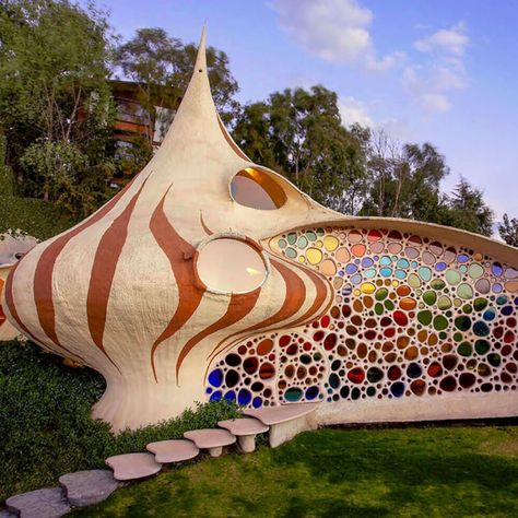 NAUCALPAN, MEXICO Nautilus House 19.4773 -99.2793 Fantastical house shaped like a seashell brings aquatic design to architecture.  A young family tired of their conventional home yearned to live in something a little more intergrated with nature. Their wish was granted by Javier Senosiain of Senosiain Arquitectos, a celebrated Mexican architect whose work is considered both pioneering and controversial in the field of bioarchitecture. Nautilus House, Aquatic Design, Organic Interior Design, Organic Interior, Beach Architecture, Houses In Mexico, Organic House, Shell House, Bottle House