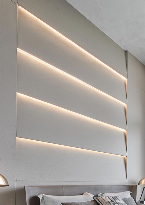 An accent wall with angled sections that also have hidden lighting that creates a soft glow. Backlit Accent Wall, Accent Wall With Led Lights, Long Wall Design, Indirect Lighting Bedroom, Accent Wall Lighting, Wall With Led Lights, Bedroom Accent Wall, Interior Cladding, Hidden Lighting