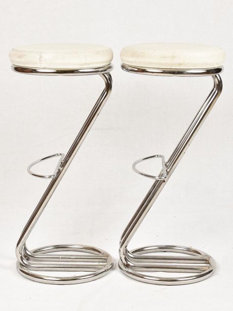 A stylish set of four chrome 'Z' shaped bar stools with footrests from the 1980s. It is recommended that they are reupholstered as there is a tear in one chair, and the faux leather is rather tired. Approx. overall 13¾" diameter x 30¾" high Approx. overall 35cm diameter x 78cm high High Stools Kitchen, 80s Furniture, Bar Chairs Design, Chrome Furniture, Chrome Decor, Chrome Bar Stools, Mid Century Modern Bar, 80s Interior, Retro Bar Stools