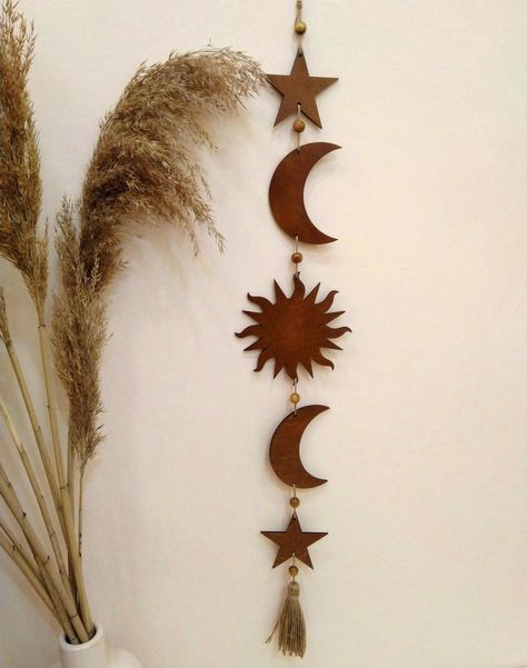 Sun, moon and stars garland is so cute decor for boho wall. This wooden boho wall hanging is a stunning decoration for your boho space! We made it in gold, brown and other natural colours. This celestial wall hanging is also decorated with wooden beads. ➤ SIZE: width 4.7 inches (12 cm) height 32.7 inches (83 cm) Witchcore Decorations, Star Home Decor, Moon Aesthetic Decor, Wall Hanging Wooden Decor, Celestial Boho Bedroom, Sun And Moon Decorations, Celestial Living Room Decor, Witchy Boho Decor Bedroom, Celestial Wall Decor