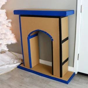 How to Make a Cardboard Holiday Fireplace | HGTV Cardboard Fireplace Christmas, Diy Cardboard Fireplace, Faux Fireplace Diy Cardboard, Tree Cardboard, Diy Christmas Fireplace, Diy Paper Christmas Tree, Cardboard Fireplace, Holiday Fireplace, Fake Fireplace