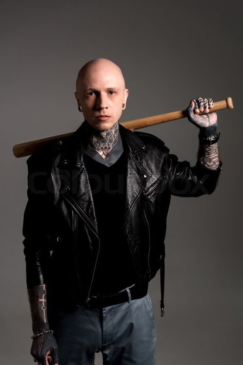 Cool tattooed man in leather jacket holding baseball bat on shoulders and looking at camera isolated on grey, stock photo | Stock Images Page | Everypixel Guy Holding Bat Reference, Holding A Bat Pose Reference, Holding Bat Behind Head Pose, Holding Bat Over Shoulder Pose, Male Pose Reference Holding Something, Holding A Pokeball Reference, Holding Baseball Bat Reference Drawing, Baseball Bat Over Shoulder Pose, Holding A Baseball Bat Reference