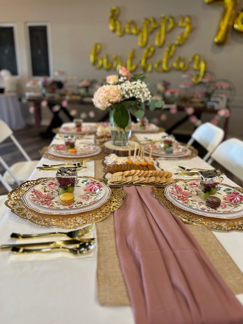 I opted for gold doilies to replace chargers.  They looked beautiful with a 10.5in white plastic plate with gold rim on top, and a 9 in paper flower printed plate on top of the white plate. White napkins are from hobby lobby, pack of 50.  Gold plastic ware pack from Amazon. Burlap runner, and a rose pink runner on top.  Fresh flowers,  and  mini desserts on opposite sides.  The dessert table was huge.  H‑E‑B Cupcakes and cake.  All other mini desserts are from Costco.Mylar balloons from Amazon. Love Flowers, My Mom, Birthday, Flowers