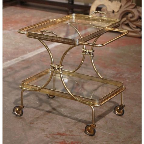 This elegant, vintage rolling bar cart was created in France, circa 1930 and attributed to Maison Bagues. The rectangular dessert table has a brass frame, small wheels with rubber tires over short straight legs, and two rectangular shelf plateaus topped with glass surfaces. Both shelves are connected by curved inward brass frame and embellished with brass rope form motif connecting the sides together. The removable top deck dressed with tainted glass features a convenient shaped utilitarian handle on each side and is decorated with a brass pierced gallery rim; the tray can be conveniently be lifted up, and be set on a table. The bottom plateau also features a decorative pierced gallery around the original glass. The classic Art Deco table is in excellent condition commensurate with age and Vintage Bar Cart Styling, Art Deco Bar Cart, Brass Bar Cart, Wood Bar Cart, Cart On Wheels, Modern Bar Cart, Metal Bar Cart, Rolling Bar Cart, Glass Bar Cart