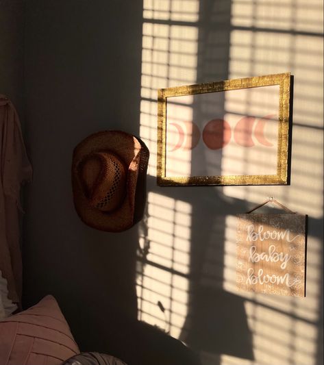 sunlight filters on a collage wall with a picture frame and a cowboy hat in the collage Cowboy Hat Room Decor, Cowboy Hat Display Ideas, Cowboy Hat On Wall, Cowboy Hat Wall Decor, Hat Hanging Ideas, Cowboy Hat Display, Cowboy Hat Wall, Hat Wall, Hanging Hats