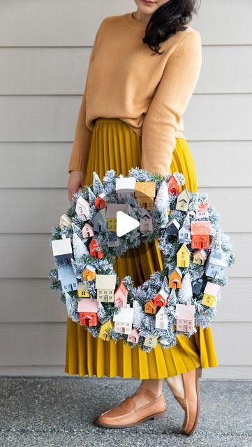 Delia - DIY on Instagram: "I’m a neutrals girl but making this paper Christmas village wreath in 🌈 colors just felt right. 👌  I made this wreath, *inspired* by the  gorgeous putz house wreath from @marthastewart , except with mini paper houses I designed, and for under $20! 🙌  All it takes is some cardstock, bottle brush trees, and a $6 wreath from @joann_stores ! Joann’s has THE perfect red/orange paper right now too. 👌  For the free cut files and printable templates check out the link in my bio.  What color paper would you choose?  #christmaswreath #christmasvillage #paperhouse #freecutfiles #cutfiles #freeprintable #craftersofinstagram" Paper Village Wreath, Putz Houses Wreath, Christmas Wreath With Houses, Putz House Wreath, Bottle Brush Wreath, Bottle Brush Tree Wreath, Putz Houses Templates Free Printable, Christmas Village Wreath, Paper Christmas Village