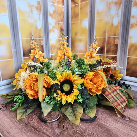 Newly added to the shop!! This headstone hugger is a beautiful way to honor and remember your loved one during the fall and Thanksgiving season. Bright sunflowers and peonies accented plaid bows. Who doesn't love a good traditional plaid for the holidays? Take advantage of the sale going on right now in the shop for this and all other seasonal decor. #headstoneflowers #gravesiteflowers #cemeteryflowers #sunflowerarrangement #memorialflowers #honorlovedones #cemeteryarrangements #vabbd #... Fall Headstone Saddles, Sunflowers And Peonies, Sunflower And Peony, Flowers For Cemetery, Fall Cemetery, Headstones Decorations, Crafting Hobbies, Gravesite Decorations, Sunflower Arrangements