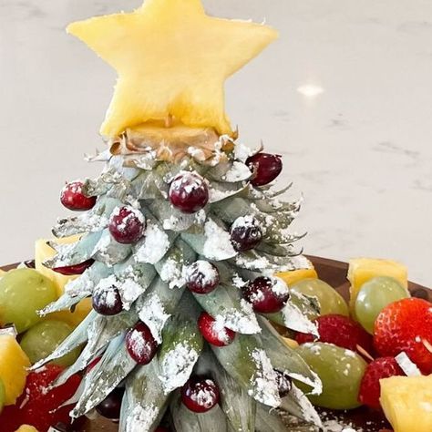 Kelsi || Content Creator on Instagram: "🎄 Christmas Tree Fruit Platter 🎄⁣ ⁣ This is THE cutest and easiest way to serve fruit at all your holiday parties!! Cut the stem off the pineapple and turn it upside down to make a Christmas tree!! I added cranberries as ornaments, a pineapple star on top and powdered sugar as snow! Inspo from the amazing ⁣@created.at.home .⁣ .⁣ .⁣ .⁣ #christmas #christmastree #christmasideas #christmastime #christmasinspiration #christmasinspo #holiday #christmasdiy #diychristmas #holidayhosting #holidayhome #christmasrecipes" Pineapple Xmas Tree, Pinapple Tree Christmas, Pineapple Serving Ideas, Pineapple Top Christmas Tree, Pineapple Christmas Tree Fruit Tray, Pineapple Tree Fruit Display, Fruit Christmas Tree Platter, Christmas Tree Fruit Platter, Christmas Fruit Platter Ideas