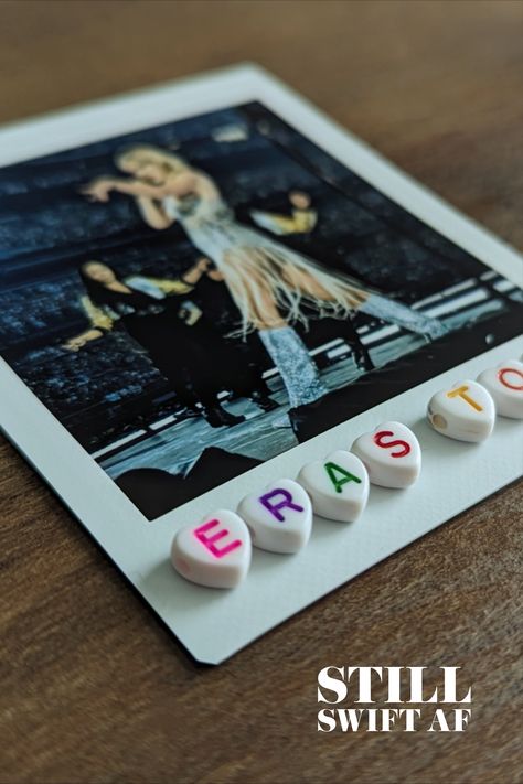 Image of a polaroid photo of Taylor Swift singing with white heart beads below that say, 'ERAS TOUR' in various colors. Taylor Swift Memory Box Ideas, Taylor Swift Shadow Box Ideas, Eras Tour Memory Frame, Concert Shadow Box Ideas, Eras Tour Shadow Box Ideas, Concert Display, Eras Tour Diy, Eras Tour Scrapbook, Eras Tour Memory