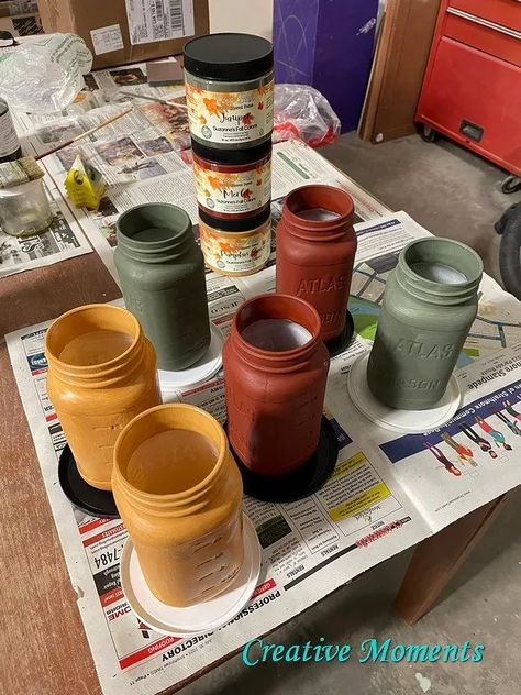 Where are my fall color fans?? These mason jars turned rustic vases are done in fall shades of green, red and yellow.  Dixie Belle Paint has released 5 limited new fall colors; juniper, merlot and pumpkin spice shown above as well as latte and cashmere This great sized mason jars come filled with spaghetti sauce and make a perfect vase. I run thru the dishwasher once emptied. Many chalk paints claim you can just paint over any surface but to have better adherence I brush… Painting Jars With Chalk Paint, Fall Mason Jar Arrangements, Autumn Mason Jars, Fall Painted Mason Jars, Pumpkin Mason Jars, Fall Crafts With Mason Jars, Fall Mason Jar Crafts Diy, Fall Painted Bottles, How To Paint Mason Jars Diy