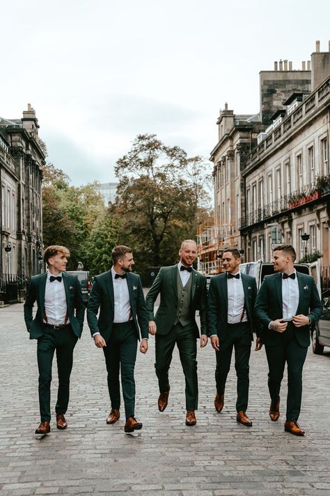 Groom & his groomsmen wear deep green suits & black bow-ties with Brogues Green Suit Men Wedding Groomsmen, Wedding Green Suits Men, Dark Green Groom Suit Grey Groomsmen, Deep Green Suit Wedding, Black Green Groomsmen Attire, Green Groomsman And Bridesmaid, Deep Green Groom Suit, Emerald Groomsmen Suits, Gromes Men Suits