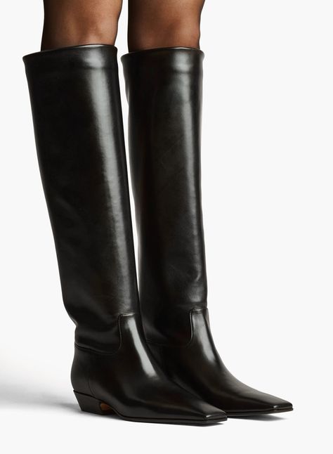 Debuting with the Pre-Fall collection's wardrobe of intuition, this sleek, square-toed boot is crafted in Italy of supple calfskin and refined by tonal topstitching. The low, inset heel provides stability and comfort for extended wear. Free of closures, it pulls on for a classic fit. Low Heel Black Knee High Boots, Khaite Shoes, Dressy Boots, Knee High Boots Flat, Material Things, Leather Outerwear, Fall 24, Black Knee High Boots, Pre Fall Collection