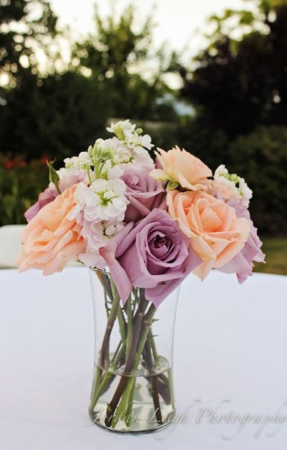 Secret Garden Wedding Theme Color Palettes, Lilac Bud Vases, Peach And Lilac Wedding Flowers, Lilac And Apricot Wedding, Lilac Wedding Flowers Table Floral Arrangements, Peach Pink Purple Wedding Flowers, Lavender Centerpieces, Spring Wedding Centerpieces, Unique Wedding Flowers