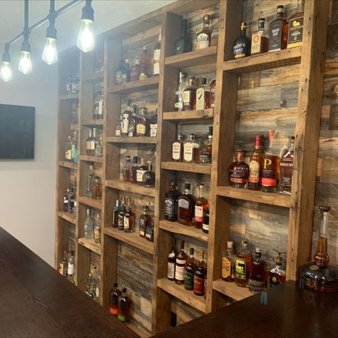 Home bar with bourbon display shelves using reclaimed barn wood Basement Bar Wall Shelves, Wall Bars For Home, Whisky Shelves, Liquor Wall Display, Bourbon Display Shelves, Bourbon Barrel Shelves, Bar Bottle Storage Ideas, Liquor Bottle Shelves, Bourbon Shelves