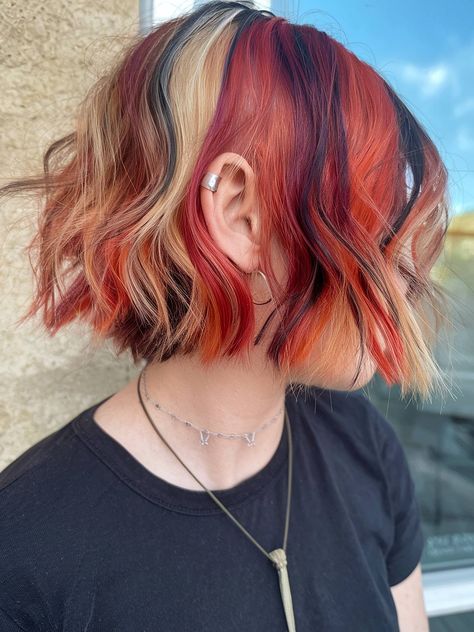 A short calico hairstyle with vibrant orange, blonde, and black streaks Short Hair Colored Highlights, Multi Colored Short Hair, Calico Hair Trend, Short Calico Hair Dye, Hair Color Sectioning Techniques, Chunky Calico Hair, Calico Short Hair, Calico Streaks, Colorblock Hair Placement