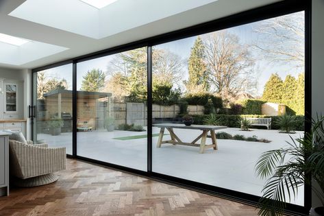 Views like these...  @sunflexuk sliding doors were the perfect choice in this home! Three wide panels with the super slim 20mm profiles allow the most wonderful view into the garden. Not only do the doors stack flush, but the threshold is also flush with the patio, allowing a seamless transition outdoors.  Finished in black, the style is perfect against the warm herringbone flooring and modern decor. We also installed two rooflights to bring even more light into this space! Herringbone Flooring, House Redo, Modern Sliding Doors, Sliding Door Handles, Herringbone Floor, Sliding Patio Doors, Seamless Transition, Sliding Panels, Corner Designs