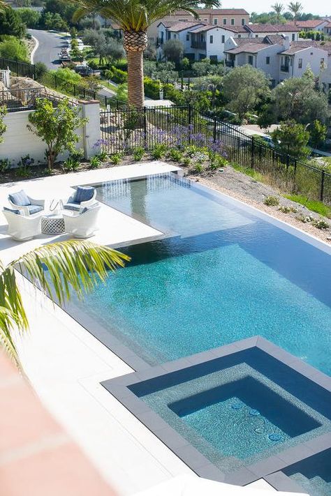 A white coffee table surrounded by white wicker chairs sits at a rectangular infinity pool finished with a spa. Infinity Pool Backyard, Pool Plans, Pool Design Modern, Outdoor Pool Area, Pools Backyard Inground, Luxury Swimming Pools, Pool Remodel, Pool Landscape Design, Swimming Pool House