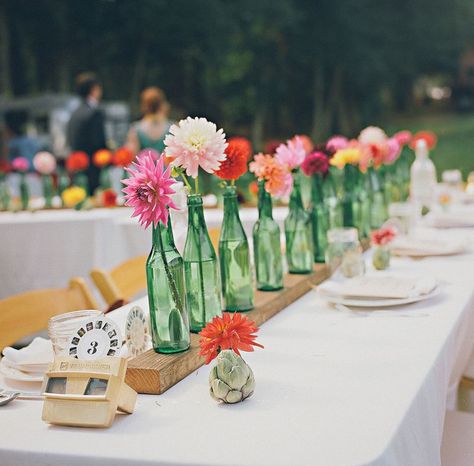 Bottle Table Centerpieces, Green Bottle Centerpieces, Flowers In Beer Bottles Wedding, Wine Bottles As Vases, Topo Chico Bottle Centerpiece, Beer Bottle Vases Wedding, Bottle Flowers, Single Flower Centerpiece, Classic Wedding Centerpieces