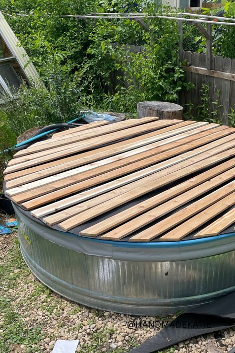 A wood-slatted cover is sitting on top of a metal stock tank pool. Stock Tank Pool Hot Tubs, Stock Tank Pool Cover, Water Trough Pool, Stock Tank Pool Deck, Plastic Stock Tanks, Stock Pool, Stock Tank Pool Ideas, Galvanized Stock Tank, Stock Tank Swimming Pool