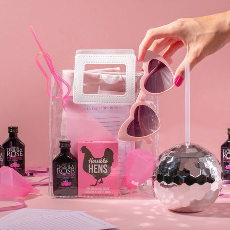 The sweetest and most fun ideas for hen party gift bags are here, Impress your hens with these hen party gift bag ideas perfect for a hen party gift bag! Check out our favourite hen party ideas here 💓   Silver discoball drinks cup with a clear straw and mini black bottles of tequila rose and a clear pvc hen party gif bag with white handles, inside it has a pink novelty straw, 'Horrible Hens' game, pink heart-shaped sunglasses, a hen do quiz and a mini black bottle of tequila rose Hen Do Gift Bag Ideas, Hen Do Gift Bags, Party Gift Bag Ideas, Disco Ball Cups, Hen Do Party Bags, Hen Party Bags Fillers, Gift Bag Ideas, Jelly Bags, Hens Party Themes