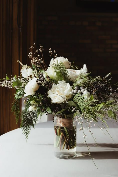 Rustic Winter Floral Arrangements, Evergreen Wedding Table Decor, Evergreen Bouquet Wedding, Winter Floral Table Arrangements, Winter Flower Centerpieces For Table, White Winter Wedding Centerpieces, Evergreen Bridal Bouquet, December Wedding Centerpieces Receptions, Winter Wedding Arrangements