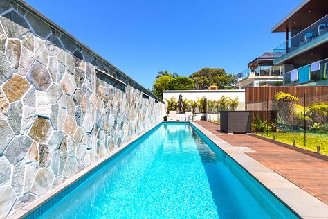 Pool Against Fence, Pool With Wall On One Side, Pool With Stone Wall, Pool Against Wall, Stacked Stone Panels, Commercial Landscape Design, Commercial Landscape, Stone Pool, Stone Wall Cladding